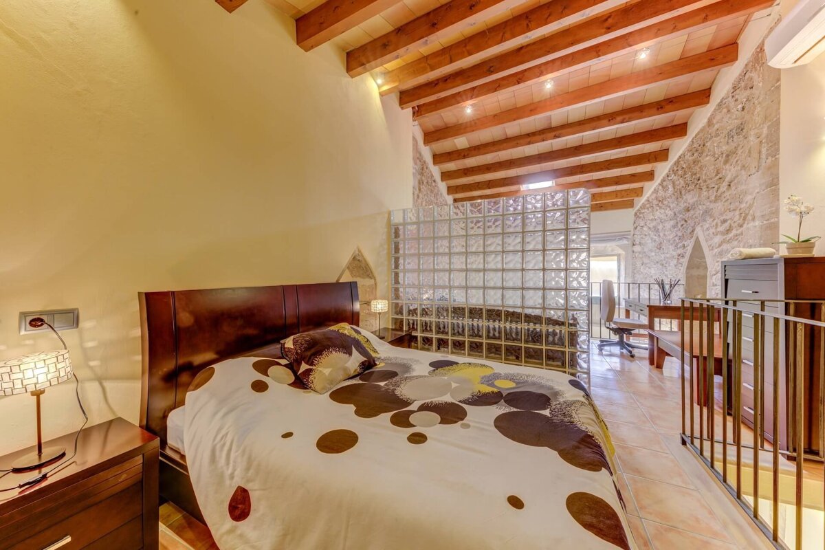 A bedroom with a bed and a glass wall