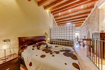 A bedroom with a bed and a glass wall