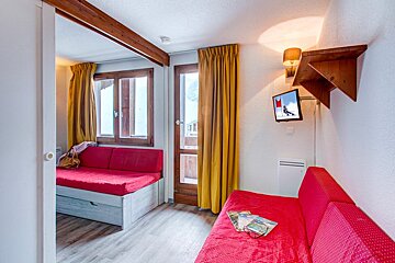 A living room with a red couch and a flat screen tv