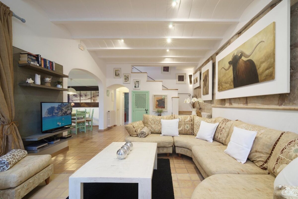 A living room with a large sectional couch and a flat screen tv