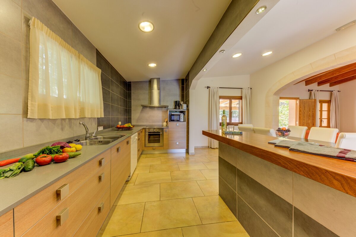 A kitchen with a lot of vegetables on the counter