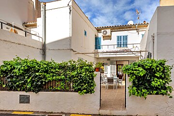 A white building with a balcony and tables and chairs
