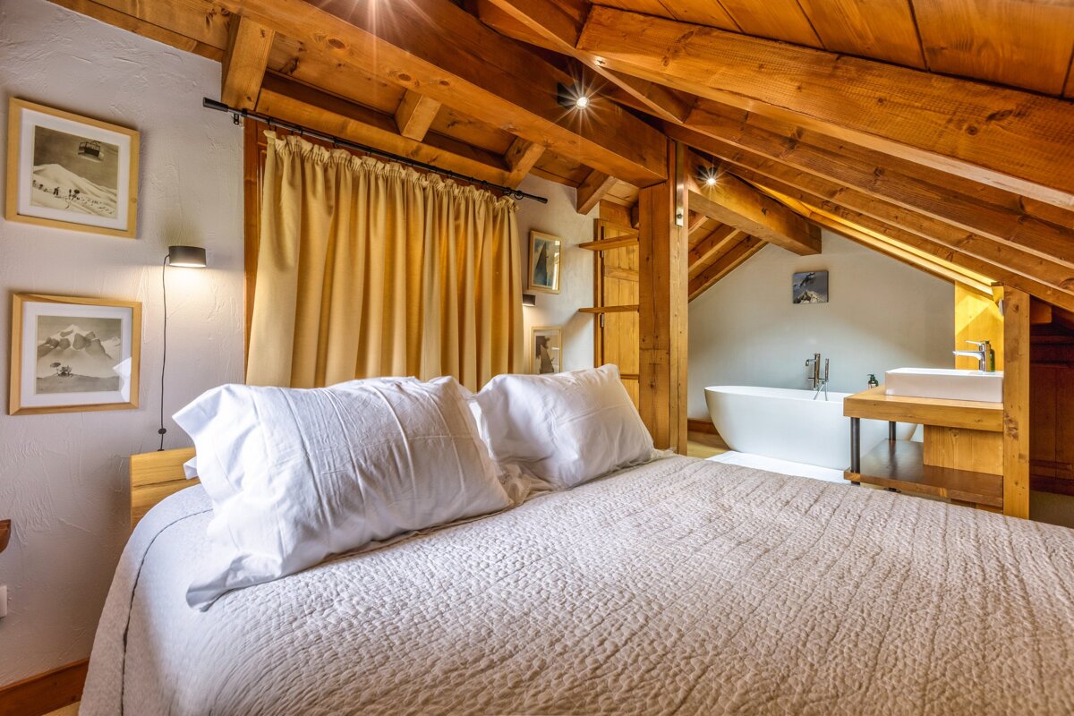 A bedroom with a large bed and a bathtub