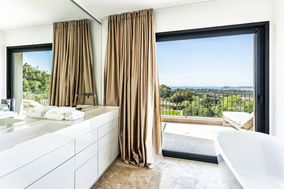 A bathroom with a sliding glass door leading to a balcony