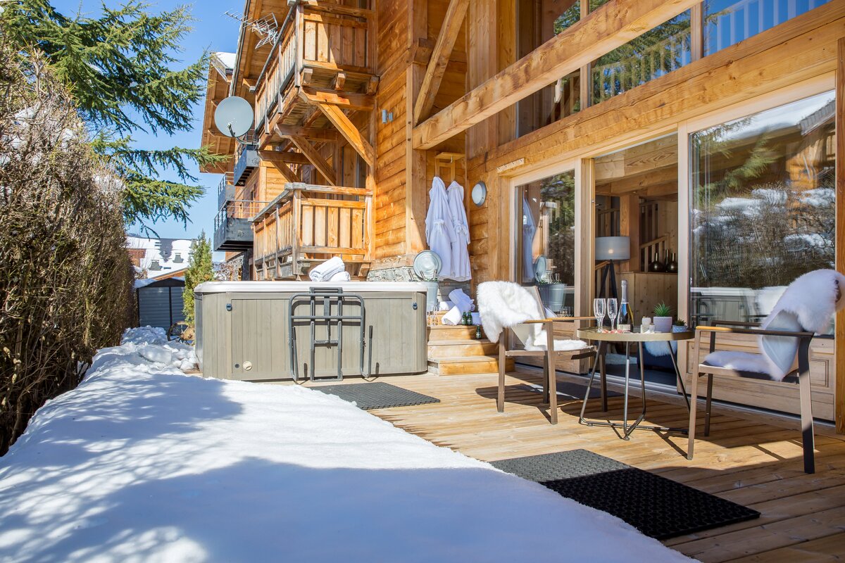 A wooden house with a hot tub in front of it