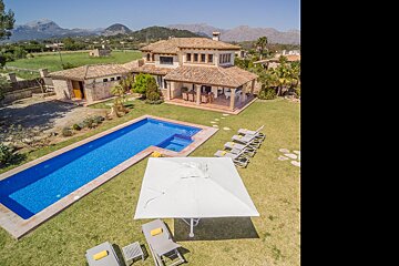 An aerial view of a house with a large swimming pool
