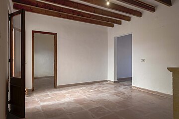 An empty room with tile floors and wooden beams