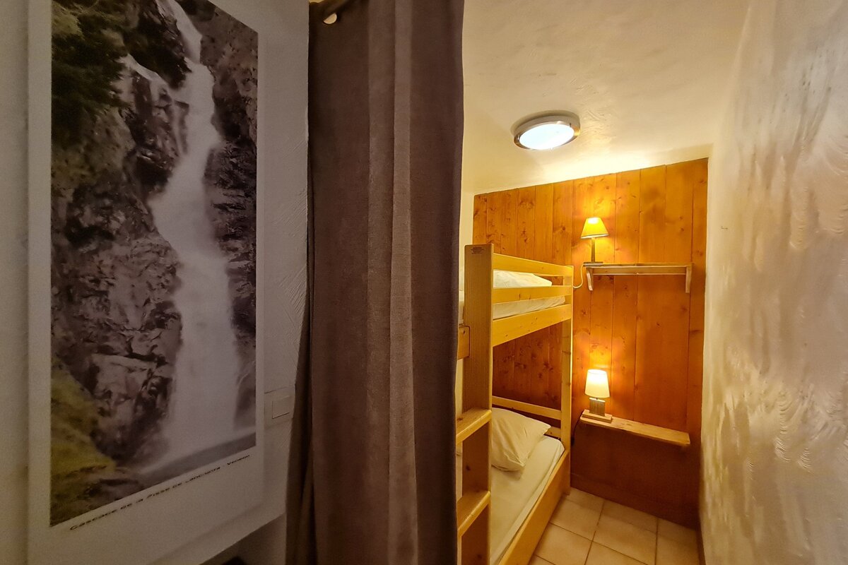 A picture of a waterfall hangs above a bunk bed