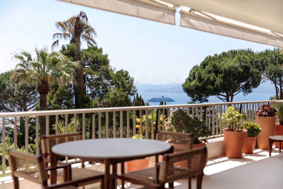 A table and chairs on a balcony overlooking the ocean