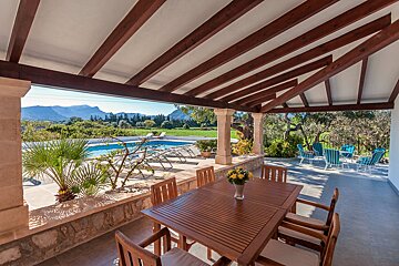 A table and chairs on a patio overlooking a pool