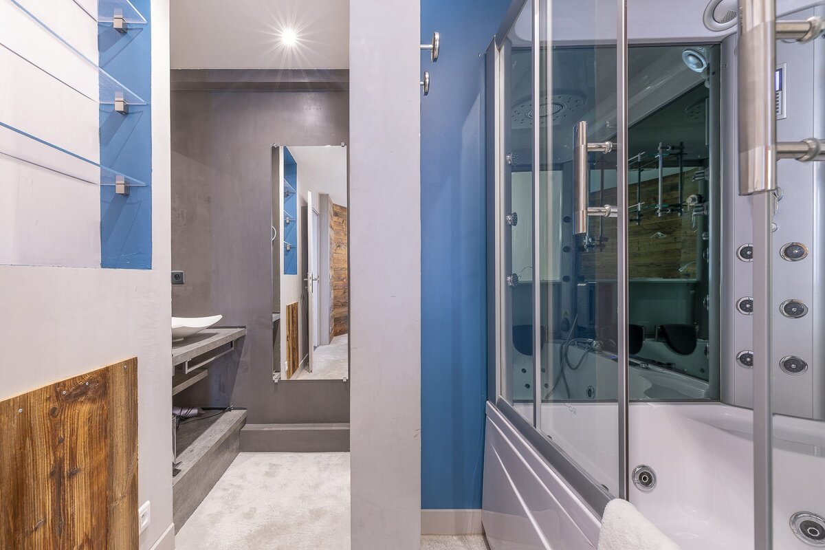 A bathroom with blue walls and a walk in shower