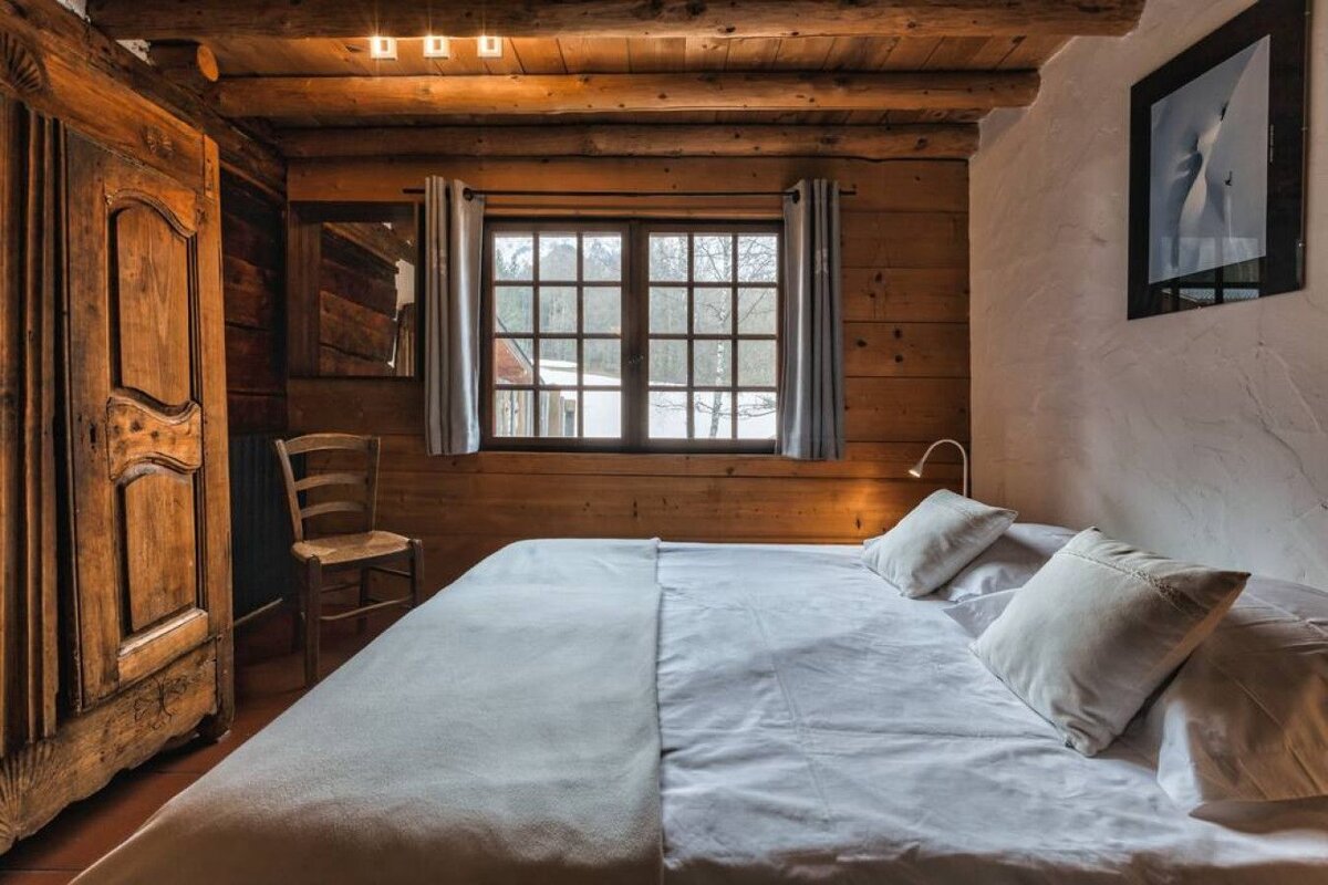 A bedroom with a bed and a picture on the wall