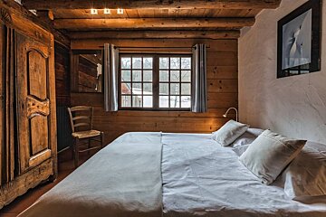 A bedroom with a bed and a picture on the wall