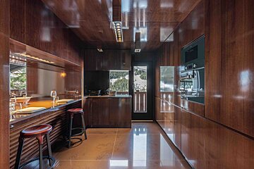 A kitchen with wooden cabinets and stools