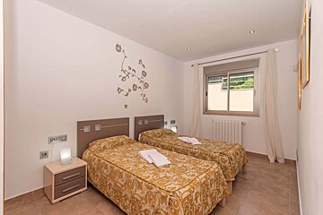 A bedroom with two twin beds and a window