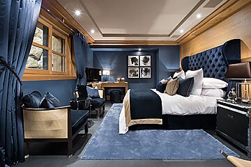 A bedroom with a large bed and blue curtains