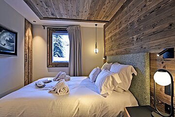 A bedroom with a large bed and a flat screen tv