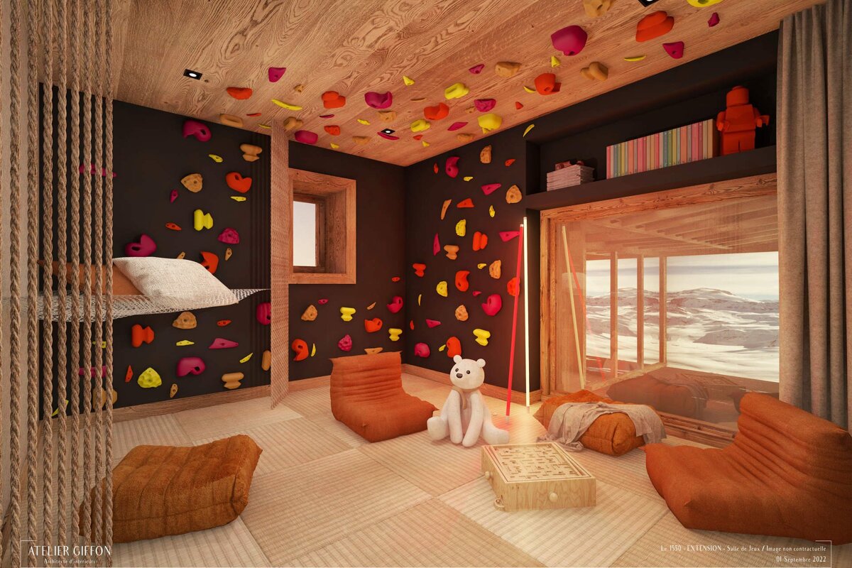 A modern room with dark walls and a wooden ceiling features a colorful climbing wall, cozy seating, a stuffed polar bear, and a panoramic view of a snowy landscape.
