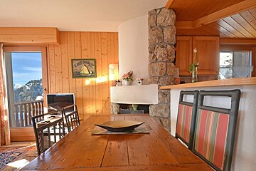A wooden dining room table with a sign on the wall that says