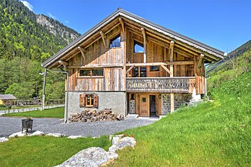 A large wooden house with a balcony in the mountains