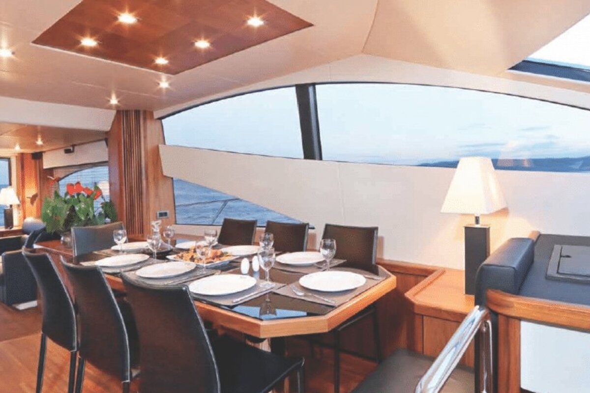 A dining room with a table and chairs and a view of the ocean
