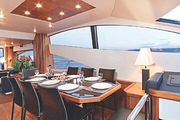 A dining room with a table and chairs and a view of the ocean