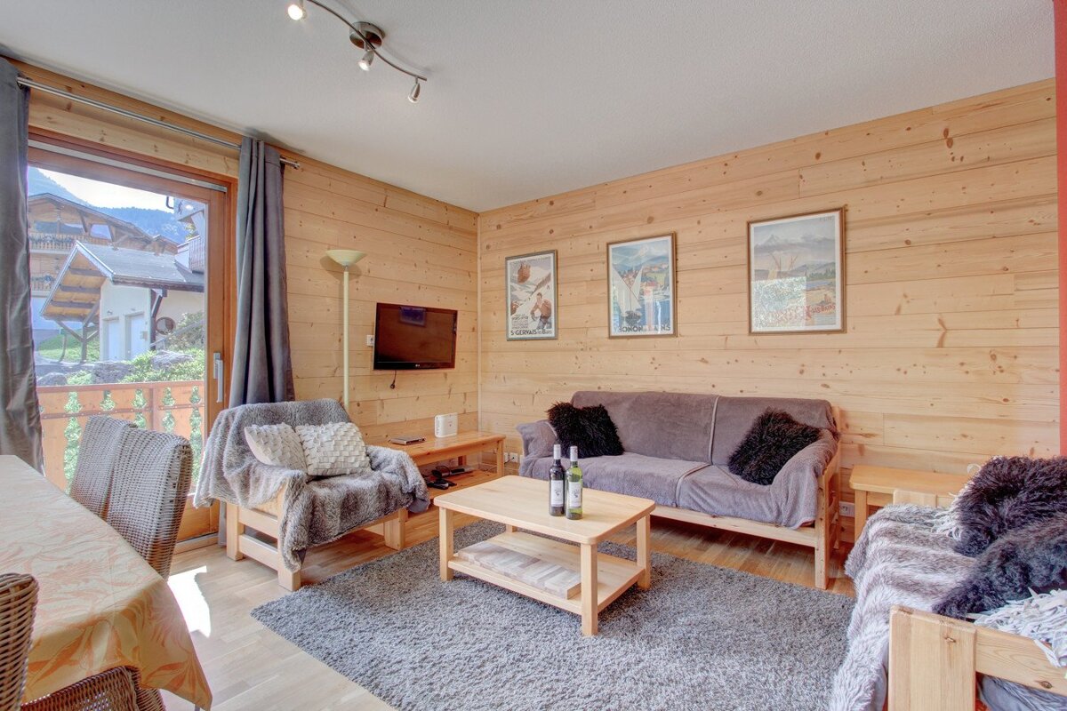 A living room with a couch and two bottles of wine