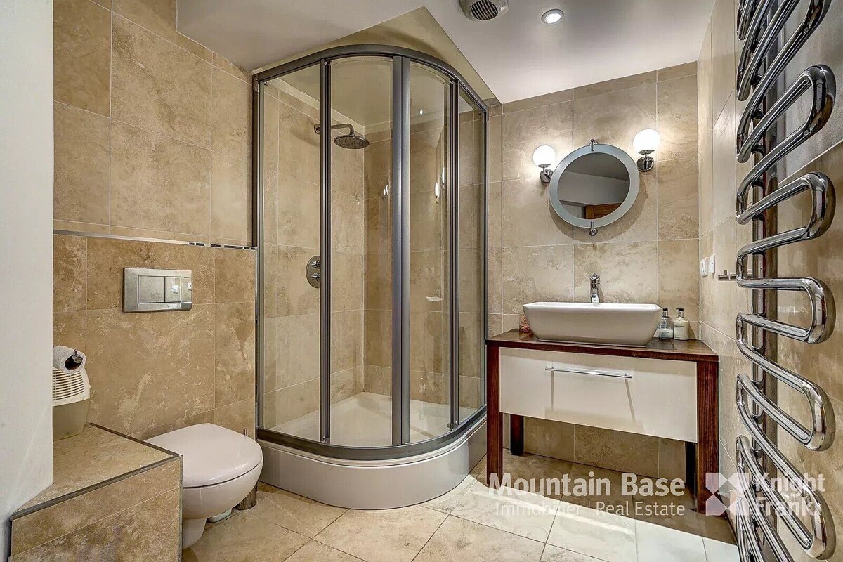 A bathroom with a toilet and a sink and a sign that says mountain base