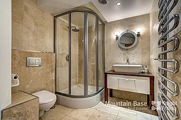 A bathroom with a toilet and a sink and a sign that says mountain base
