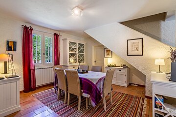 A dining room with a table and chairs and a rug