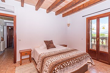 A bedroom with a bed with a leopard print blanket