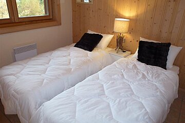 A bedroom with two beds and a lamp