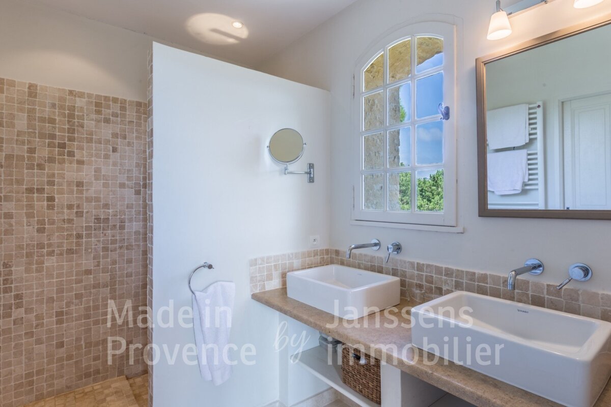 A bathroom with two sinks and a mirror says made in provence by immobilier