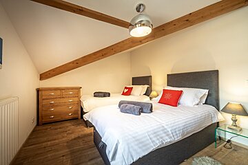 A bedroom with two beds and a dresser