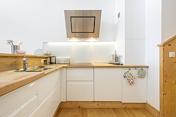 A kitchen with white cabinets and wooden counter tops
