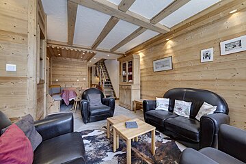 A living room with a table and chairs and a heart on the wall