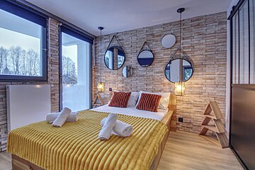 A bedroom with a brick wall and a large bed