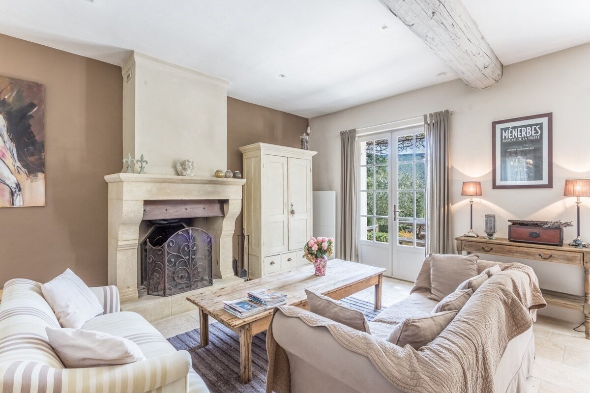 A living room with a fireplace and a poster that says menherbes