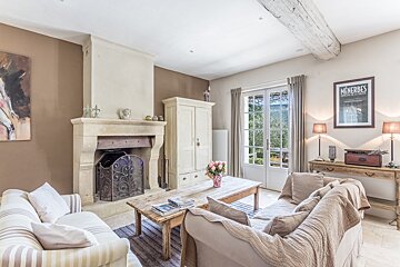 A living room with a fireplace and a poster that says menherbes