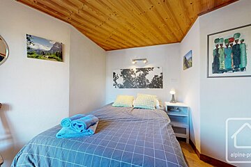 A bedroom with a bed and a picture on the wall that says alpine-pro