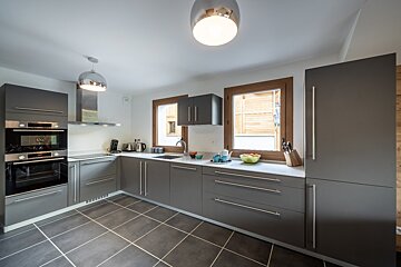 A kitchen with gray cabinets and stainless steel appliances
