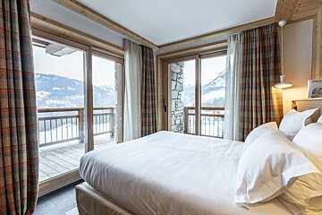 A room with a bed and a curtain behind it