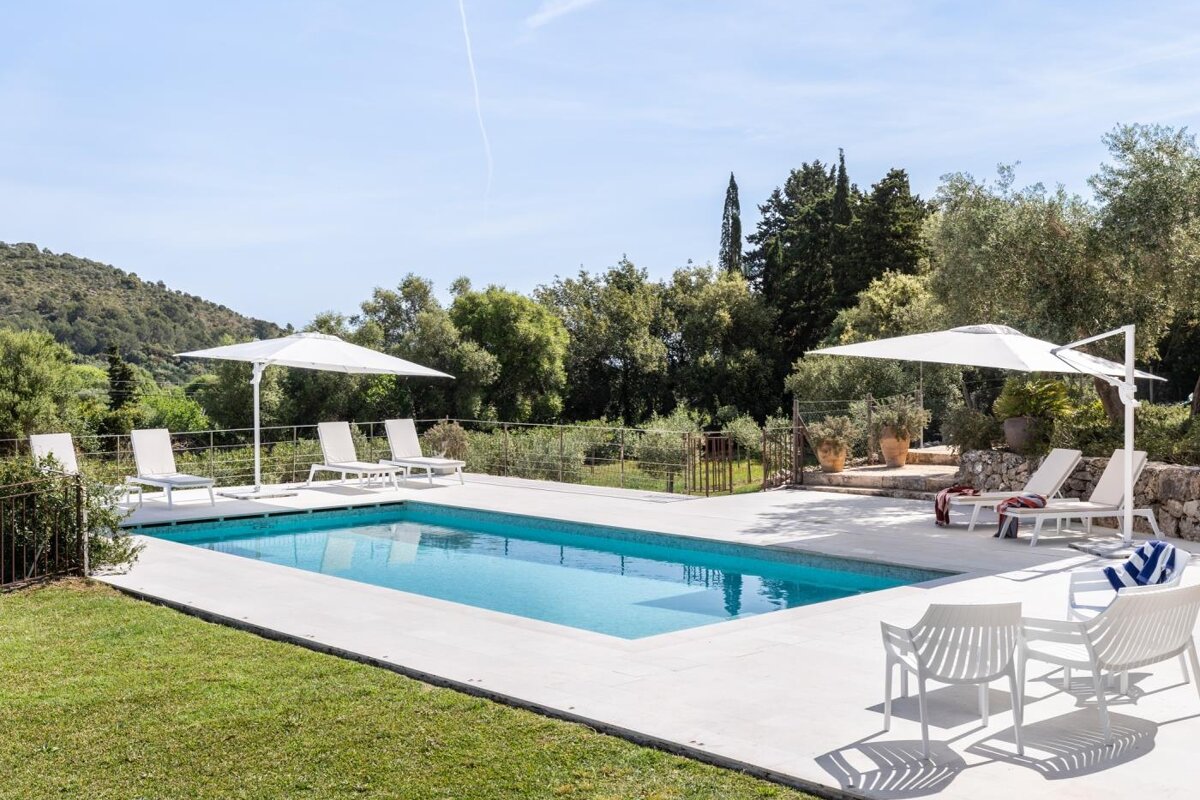 A swimming pool with chairs and umbrellas around it
