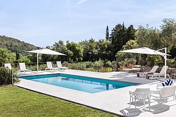 A swimming pool with chairs and umbrellas around it