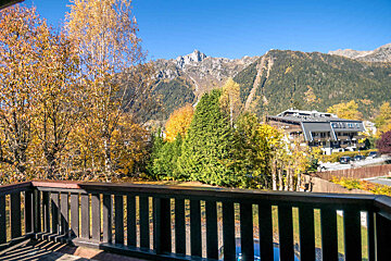 A balcony with a view of mountains and trees