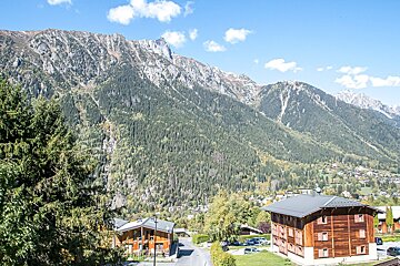 A mountain landscape with a few houses in the foreground