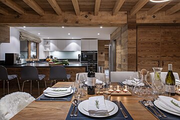 A bottle of wine sits on a table in a kitchen