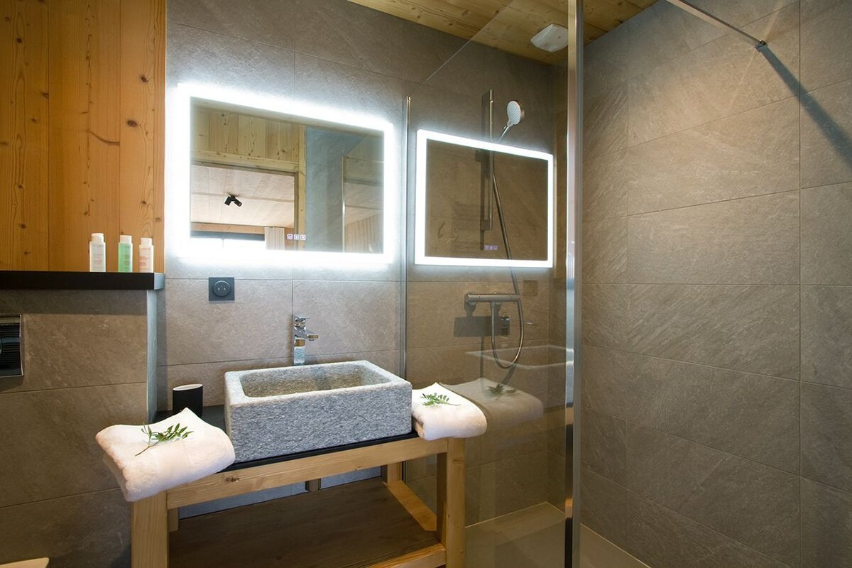 A bathroom with a stone sink and a mirror