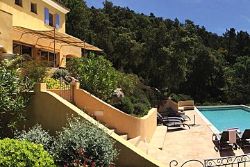 A large house with a swimming pool in front of it