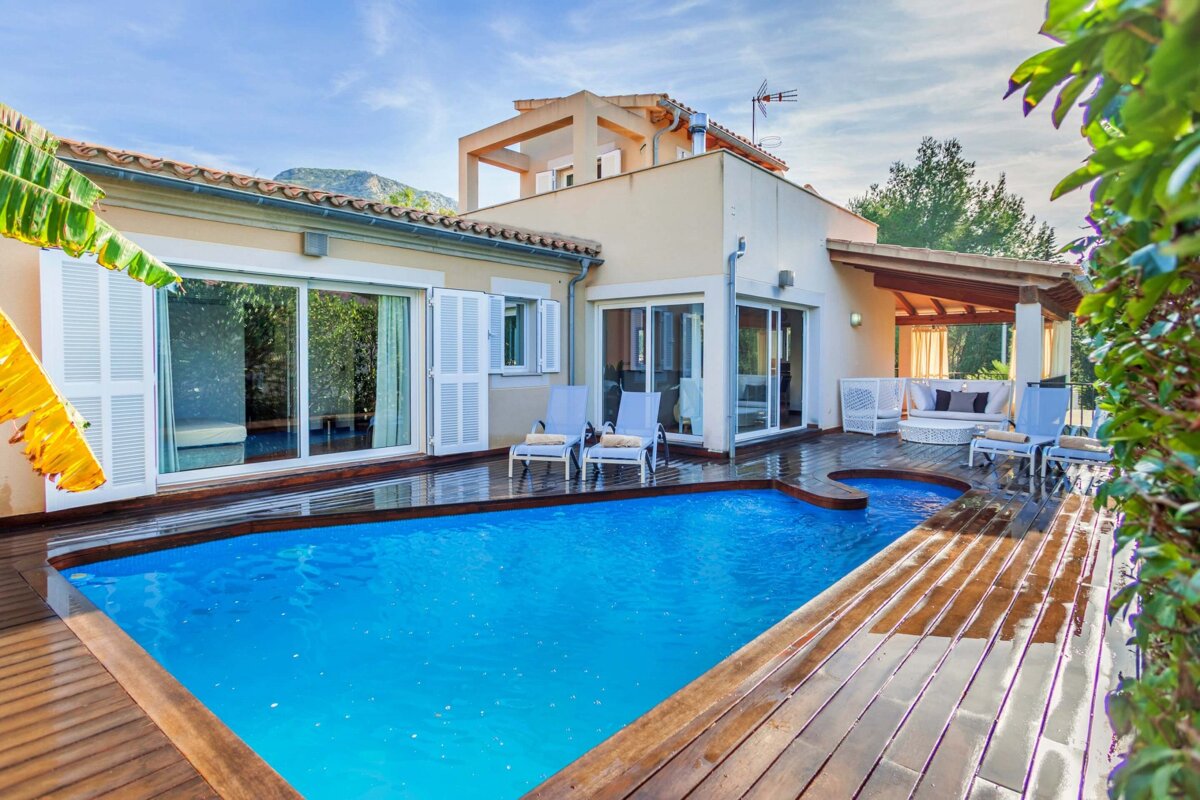 A house with a large swimming pool in front of it